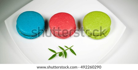 Different types of macaroons on a white plate.