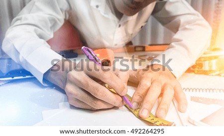 Asian man business engineer start to drawing his project architecture concept using Measuring Tape and his pen on paper work on the desk, fantasy picture style mix vintage filtered.
