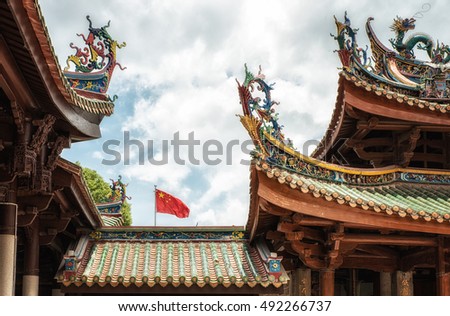 Art of Chinese temple roof with chinese flag in the background