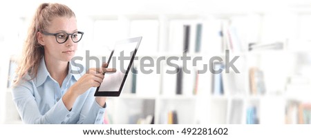 woman with tablet in hand pointing finger on screen