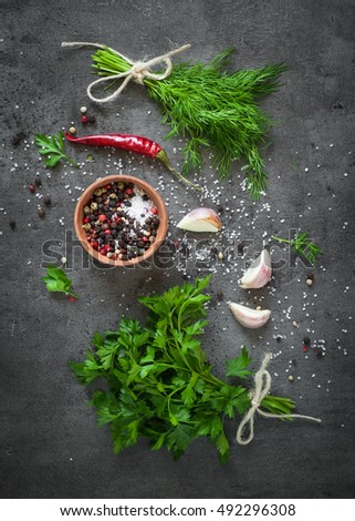 Herbs and spices at dark slate table. Parsley, dill, garlic and pepper. Ingredients for cooking.