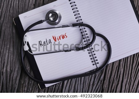 "Rota Virus" Word on Note book With Stethoscope on wooden background. Royalty-Free Stock Photo #492323068