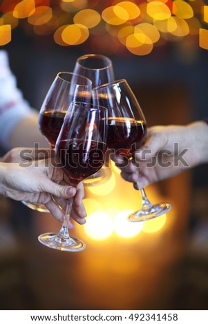 Clinking glasses of wine in hands on bright lights background. Event celebration 