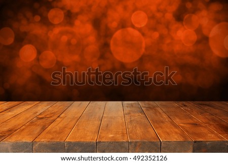 wooden table of free space and halloween background of orange color 