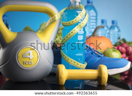 Fitness theme with healthy food. Place for typography and logo. Beautiful reflections. Bright colorful blue background. Lots of vegetables, fruits and fitness equipment. Healthy lifestyle concept. 