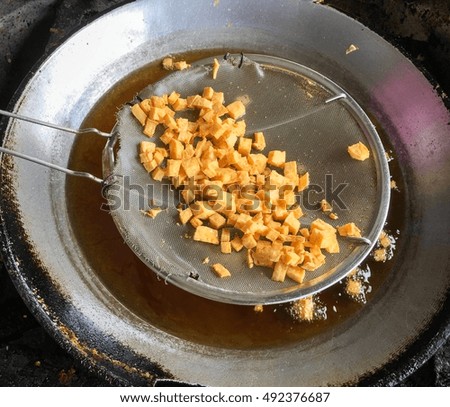 Bean curd fried in pan.