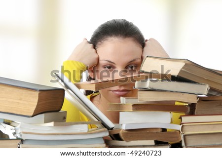 Young woman sitting behind books