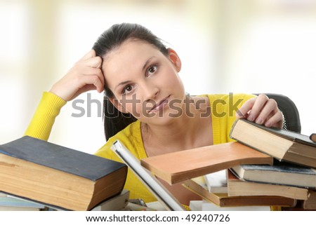 Young woman sitting behind books