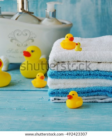 stack of colorful towels and bath duck on the table, accessories for the bathroom