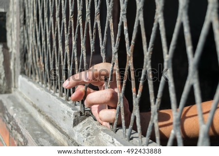 Hands of the woman on a steel lattice close up
