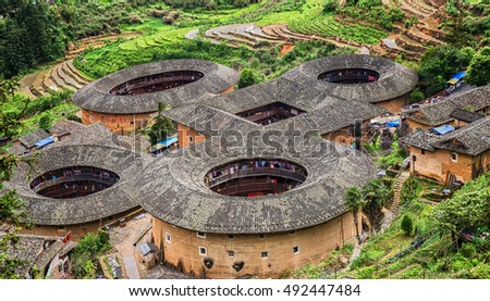 Traditional earthen Tulou Chinese huts, a landmark tourist attraction from the Fujian province of China. These large round huts are still being lived in today by the Hakka people. Royalty-Free Stock Photo #492447484