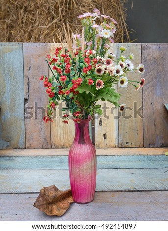 Plastics flower wedding decoration in vase, beautiful flower on wooden background. vintage style.selective focus.