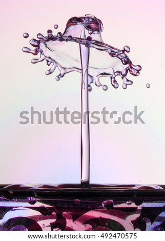 Water splash with jet and crown on pink background