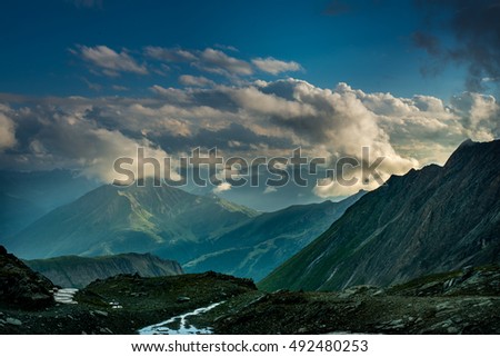 A great view of the green hills glowing by sunlight. Location famous resort Grossglockner High Alpine Road, Austria. Europe. Artistic picture. Beauty world.