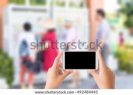 woman use mobile phone and blurred image of some asian tourists are using beverage vending machine