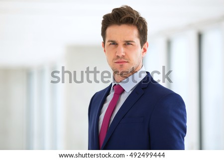 Portrait of confident young businessman wearing suit in office