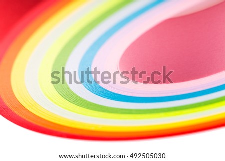 curled in a roll, twisted multicolored paper ribbon like a rainbow. Macro lens closeup shot 1:1