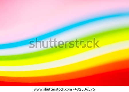 curled in a roll, twisted multicolored paper ribbon like a rainbow. Macro lens closeup shot 1:1