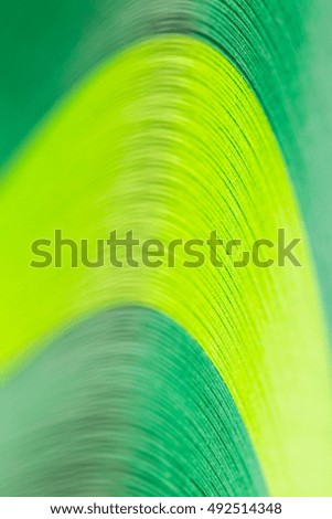 fragment of bundle green paper ribbons on a white background, in macro lens shot small-DOF for screen wallpapers