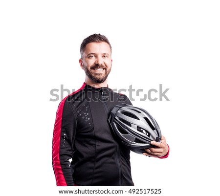 Hipster man in sports sweatshirt holding helmet, studio shot