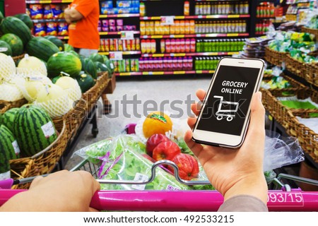 Smart phone with grocery shopping online on screen over blur supermarket background, retail business and technology concept Royalty-Free Stock Photo #492533215