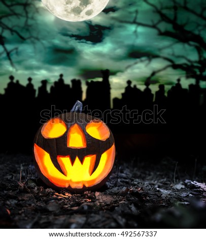 Scary halloween pumpkin with graveyard background. Empty space for text