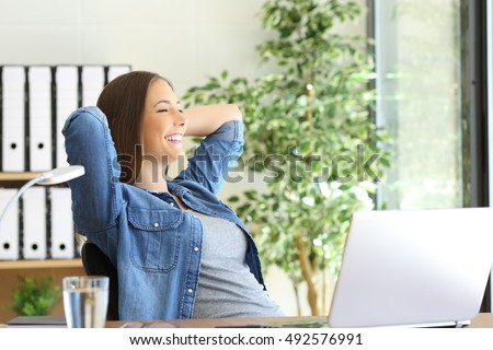 Side view of a satisfied entrepreneur with a new job looking through the window at office Royalty-Free Stock Photo #492576991