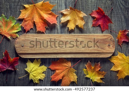 autumn background with signboard, orange leaf on old grunge wood deck, copy place for inscription, top view, tablet for text.