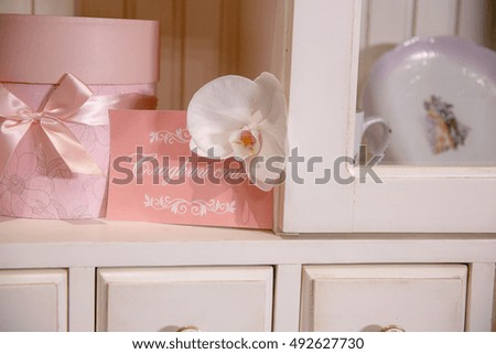 Pink card and box stand on the buffet shelve