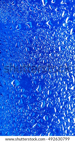 drops of water on glass with blue background in macro lens shot small-DOF for screen wallpapers