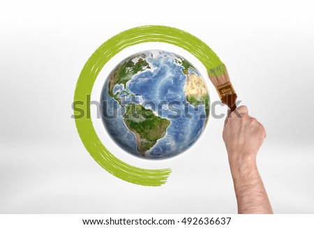Man's hand encircles globe with a brush with green paint. Protection of the planet. Save planet. Environment and ecology. Royalty-Free Stock Photo #492636637
