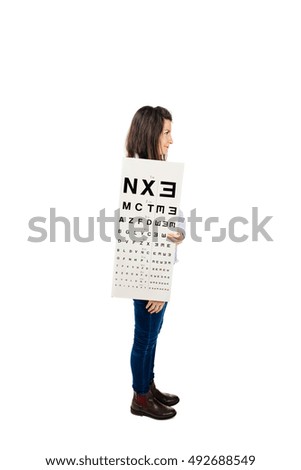 Side photo of woman holding eye chart in medical clinic - isolated on white.