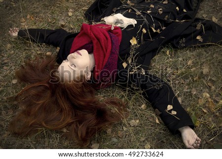 Young beautiful red-haired girl dressed like a witch in a black gown and dark clothes, with long hair, looks like a fox, 
holding animal skull, 
runes and tarot in the autumn forest. Divination