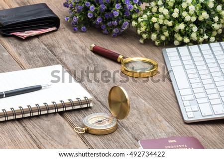 Money bag with compass and computer keyboard on wooden boards abstract background