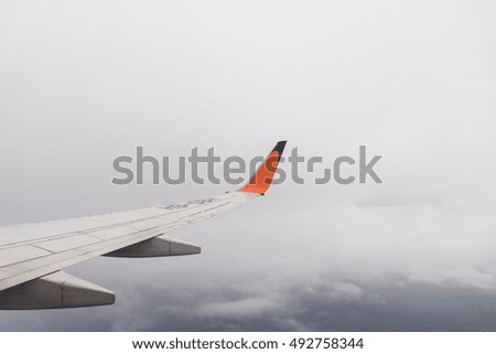 Aircraft wing flying on cloudscape, over clouds