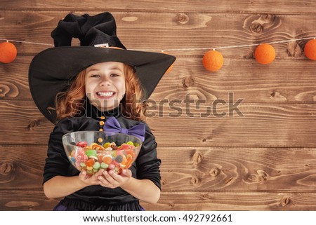 Happy Halloween! Cute little witch with candy. 