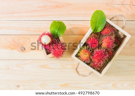 Rambutan fruit in box onwooden background