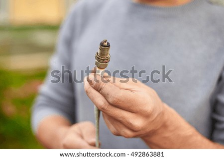 Close up plug spark in hands of mechanic