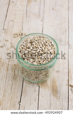 Sunflower seeds in a glass jar on wooden table.