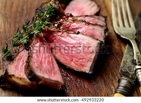 sliced grilled lamb steak on a cutting board Royalty-Free Stock Photo #492933220