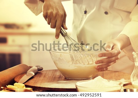 cook in kitchen and table of food 