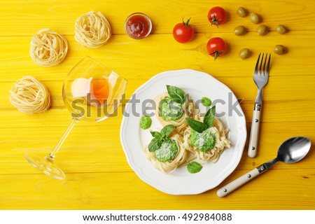 Delicious tagliatelle pasta with ingredients on wooden table