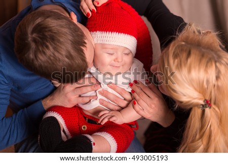 Portrait of Christmas family of three persons happy smiling. Mom, dad and son little santa celebrates Christmas and New Year, happy family holidays