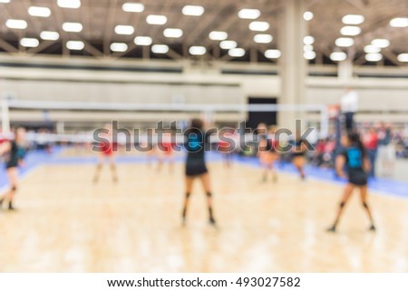 Blurred image group of teen girls playing indoor volleyball. Volleyball competition blur background. High school volleyball tournament concept.