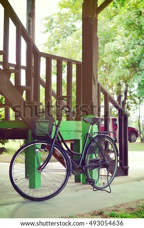 Old bicycle vintage park  with old wooden building Structure background (toned picture)
