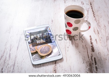 Tablet with personal loan page and black coffee on wooden table. Top view.  Photo on screen coming from my gallery.