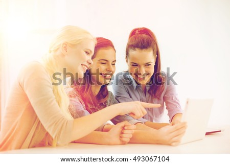 technology, internet, school and education concept - group of smiling teenage students with tablet pc computer at school