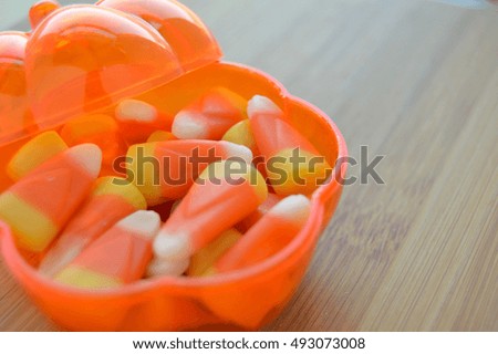 Candy corn in a clear pumpkin candy dish.