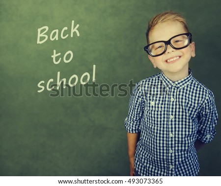 Cheerful smiling little boy on a green background. Looking at camera. School concept
