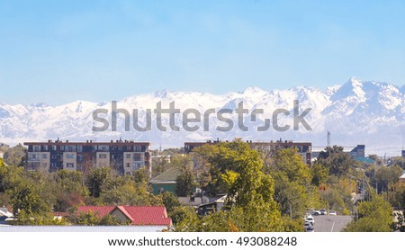 
cityscape in the background of snow-capped mountains